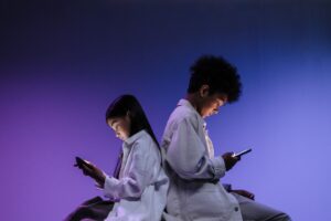 Personas diversas usando dispositivos tecnológicos en una oficina moderna, iluminada con luz natural.