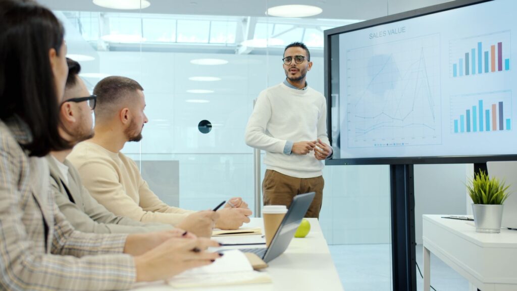 Equipo diverso analiza datos de embudo de ventas con IA en oficina moderna.
