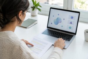Una investigadora contrasta un informe impreso con una interfaz de inteligencia artificial en su portátil.